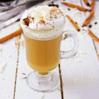 Homemade vegan pumpkin spice latte with whipped cream and a cinnamon stick