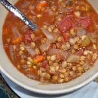 Close-up of vegan tomato lentil soup with barley in a bowl