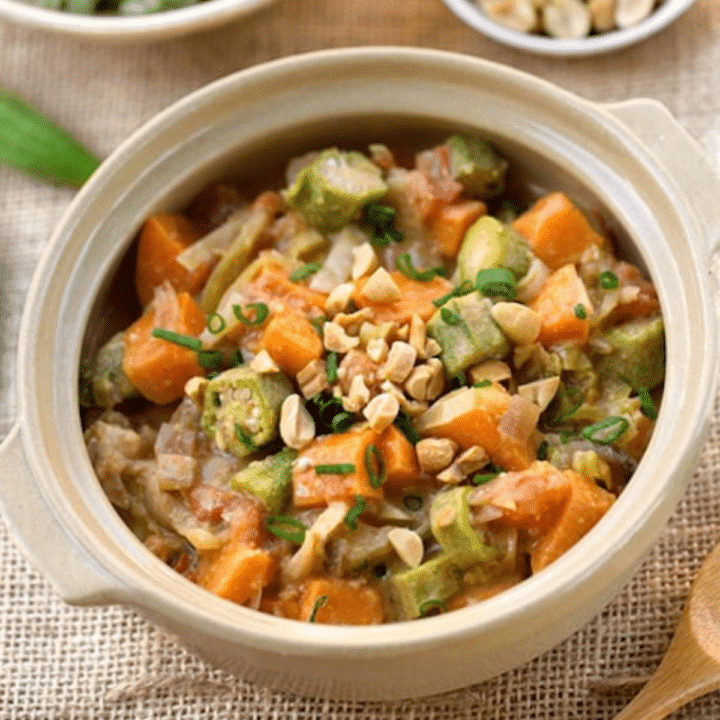 West African peanut and okra stew with sweet potatoes and chopped peanuts in a cream ceramic pot