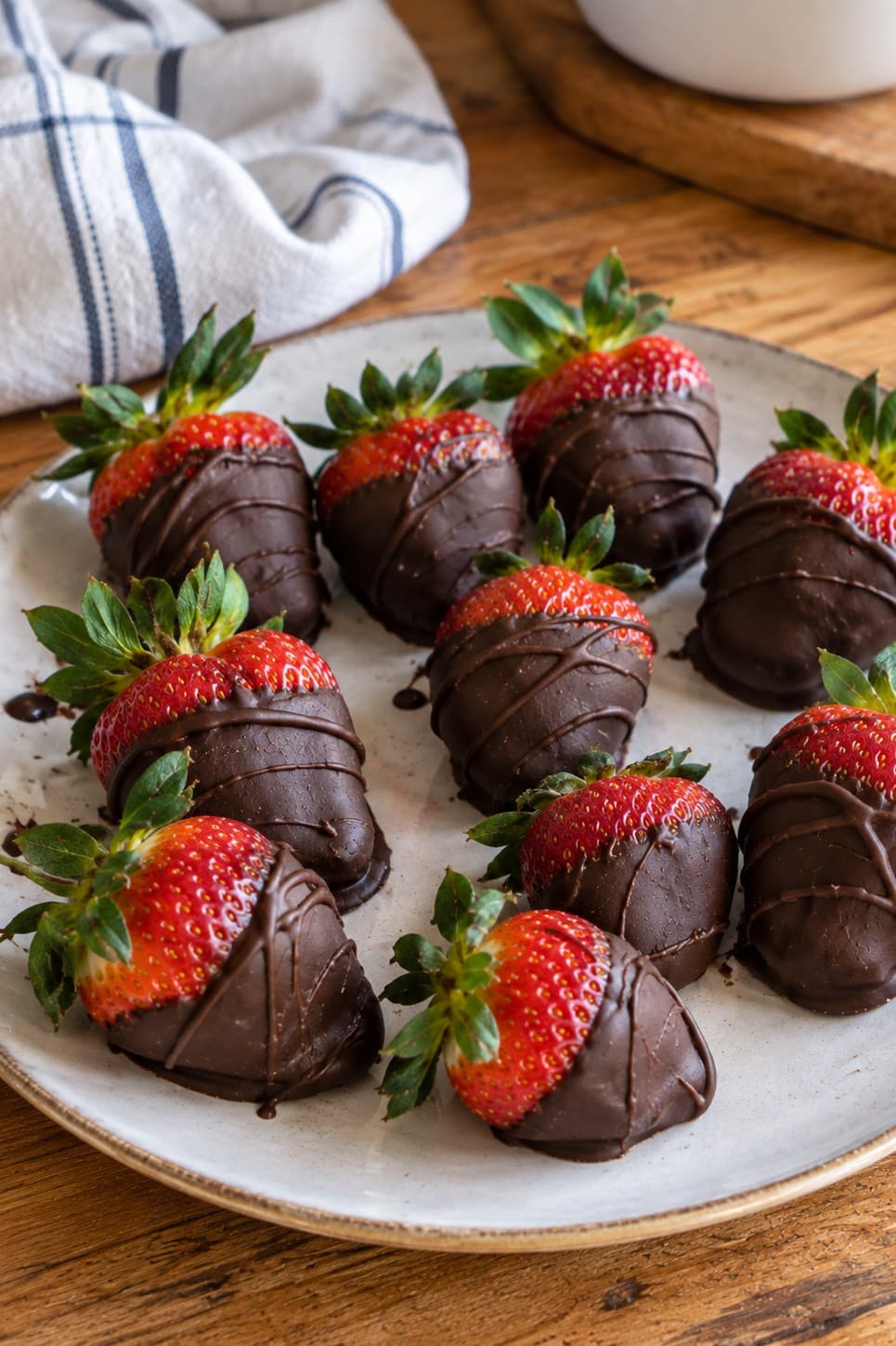 Plate of vegan chocolate covered strawberries with drizzled dark chocolate