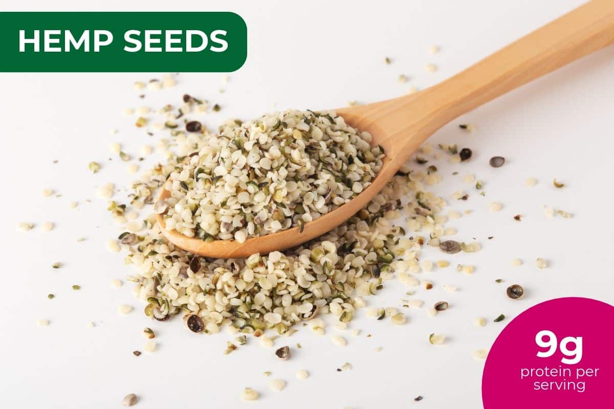 Hulled hemp seeds on a wooden spoon, labeled 9 g protein per serving