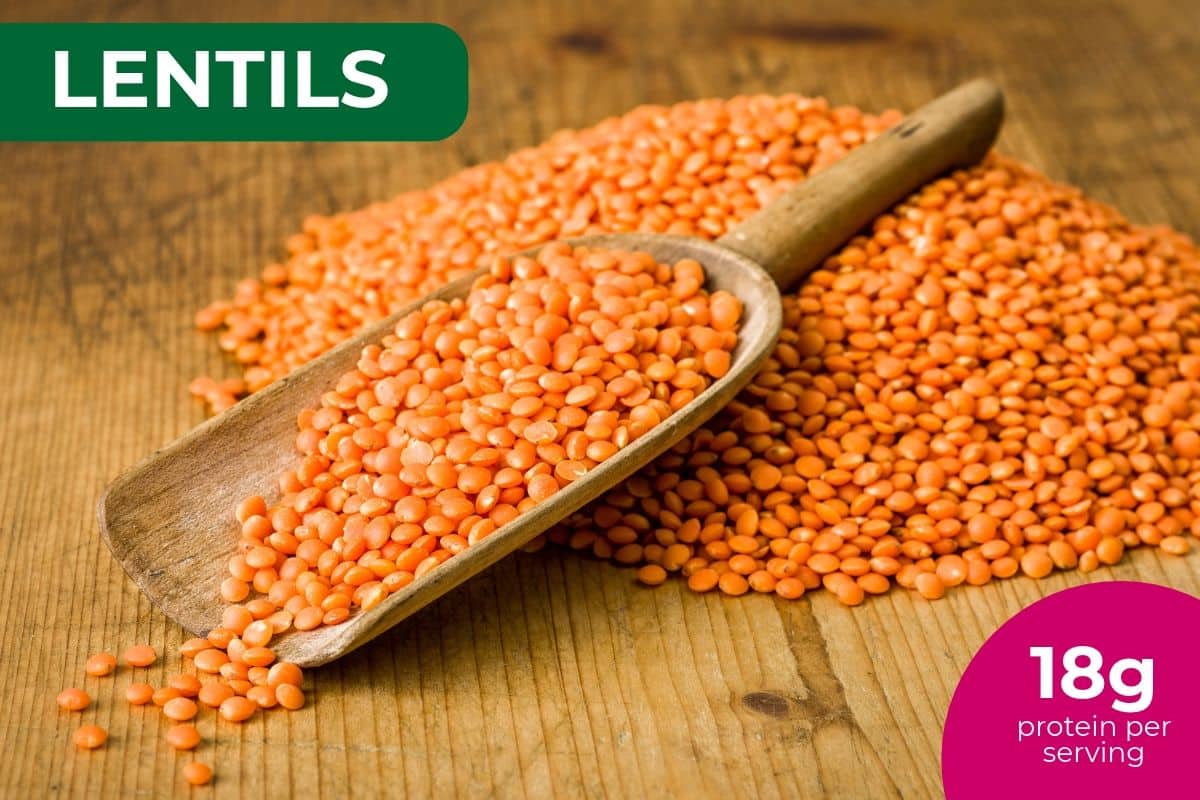 Red lentils spilling from a wooden scoop, labeled 18 g protein per serving