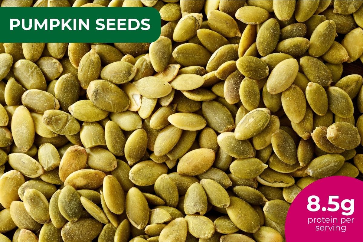 Close-up of green pumpkin seeds (pepitas), labeled 8.5 g protein per serving
