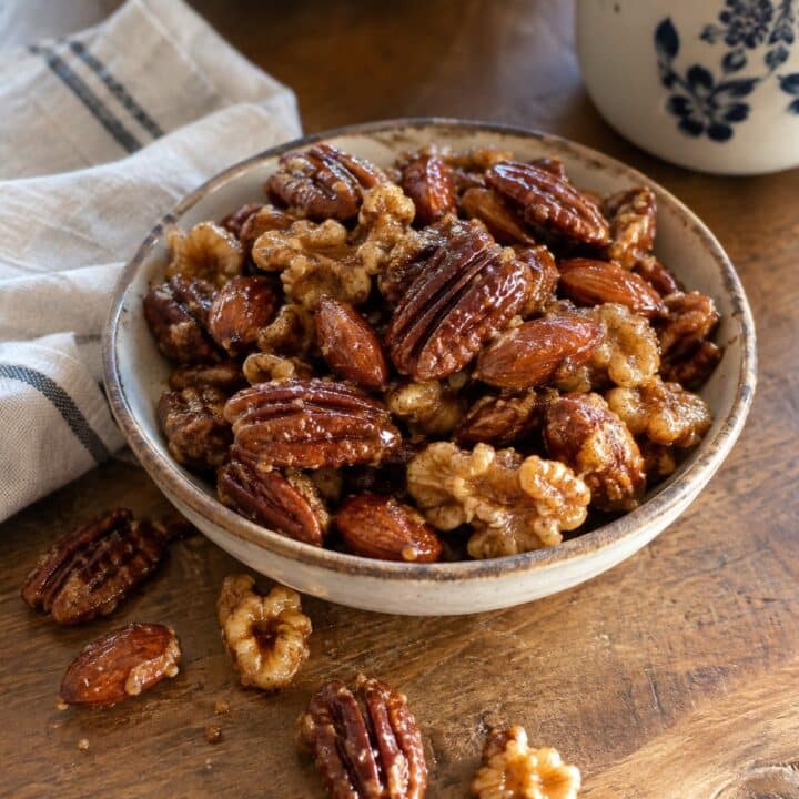 Sweet and spicy glazed nuts with pecans, almonds and walnuts in a ceramic bowl